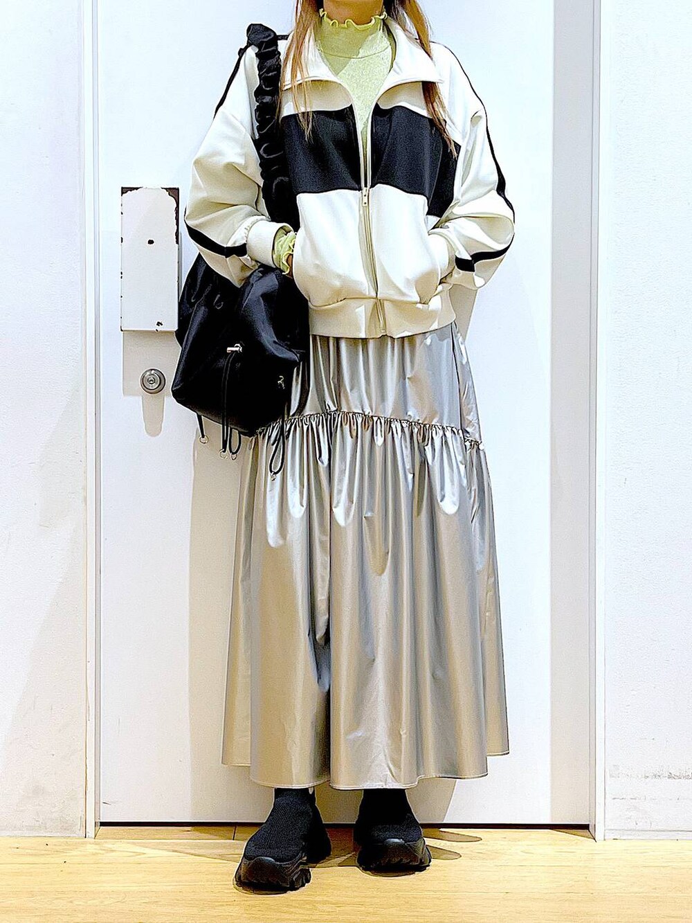 グリーン系のTシャツ/カットソー、ベージュ系のブルゾン、ブラック系のスニーカーを着用したレディースの春コーディネートの6枚目の写真