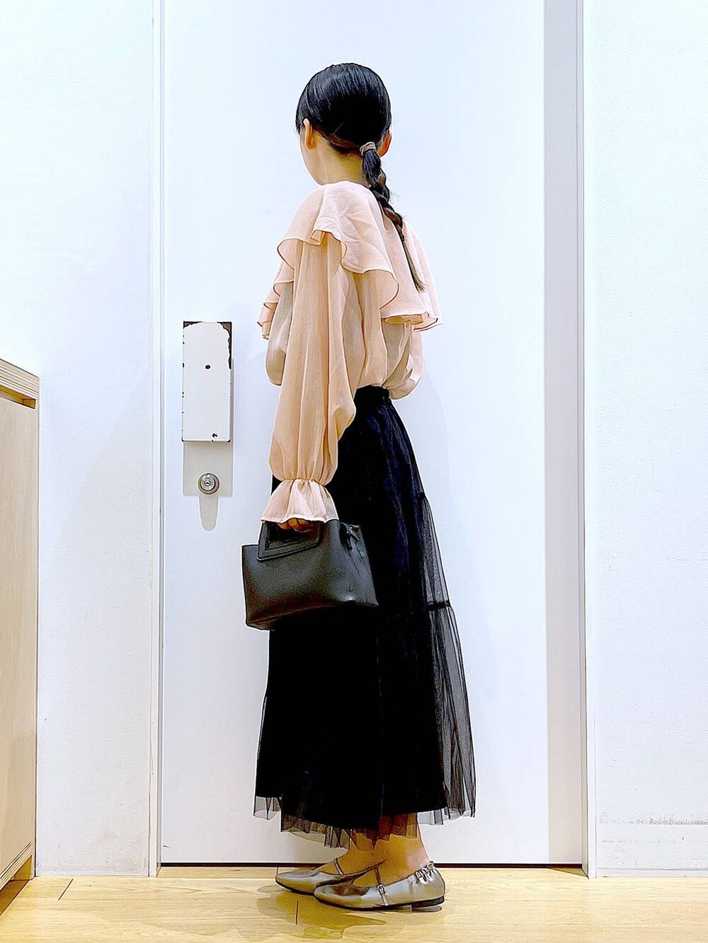 ブラック系のスカート、ブラック系のショルダーバッグ、その他のパンプスを着用したレディースの春コーディネートの3枚目の写真