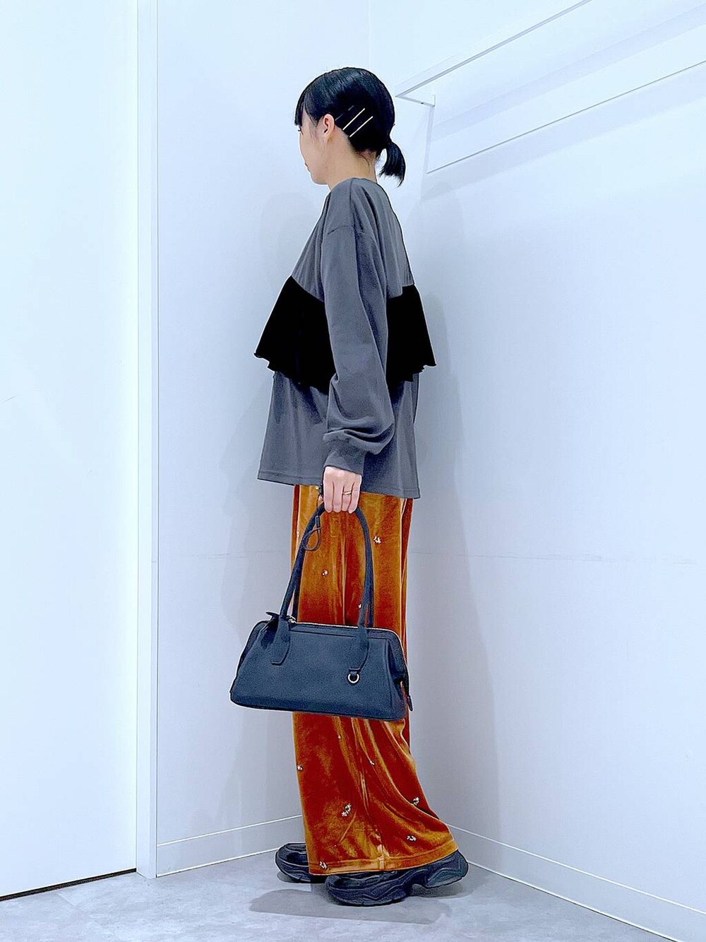 ブラック系のローファー、ブラック系のハンドバッグ、オレンジ系のその他パンツを着用したレディースの秋コーディネートの3枚目の写真