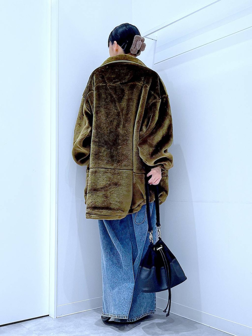 グリーン系のブルゾン、その他のニット/セーター、ブルー系のデニムパンツを着用したレディースの冬コーディネートの5枚目の写真