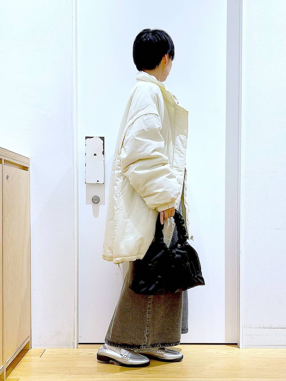 シルバー系のローファー、ホワイト系のその他アウター、ブラック系のショルダーバッグを着用したレディースの冬コーディネートの4枚目の写真