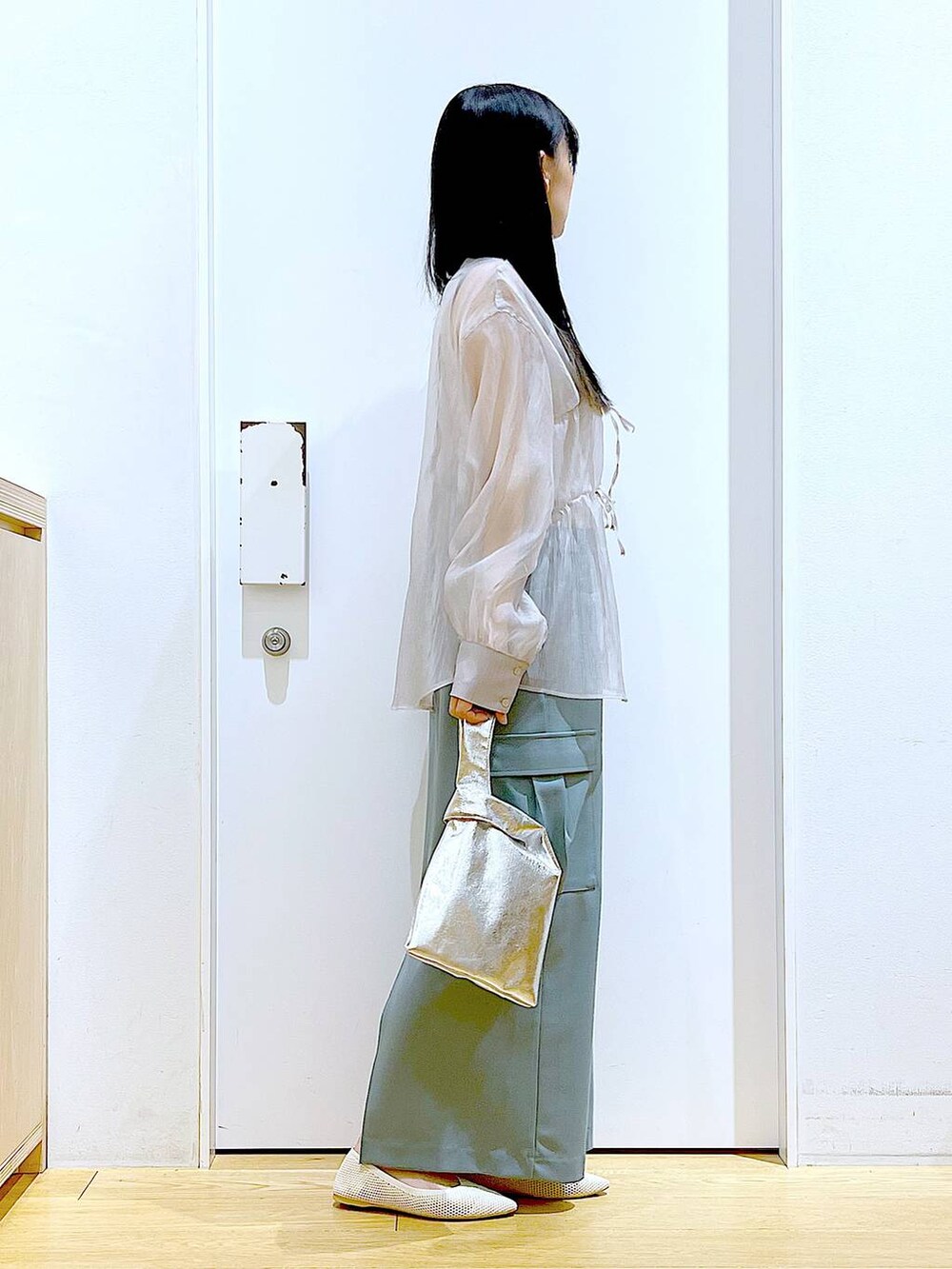 シルバー系のショルダーバッグ、グレー系のシャツ/ブラウス、ホワイト系のパンプスを着用したレディースの春コーディネートの4枚目の写真