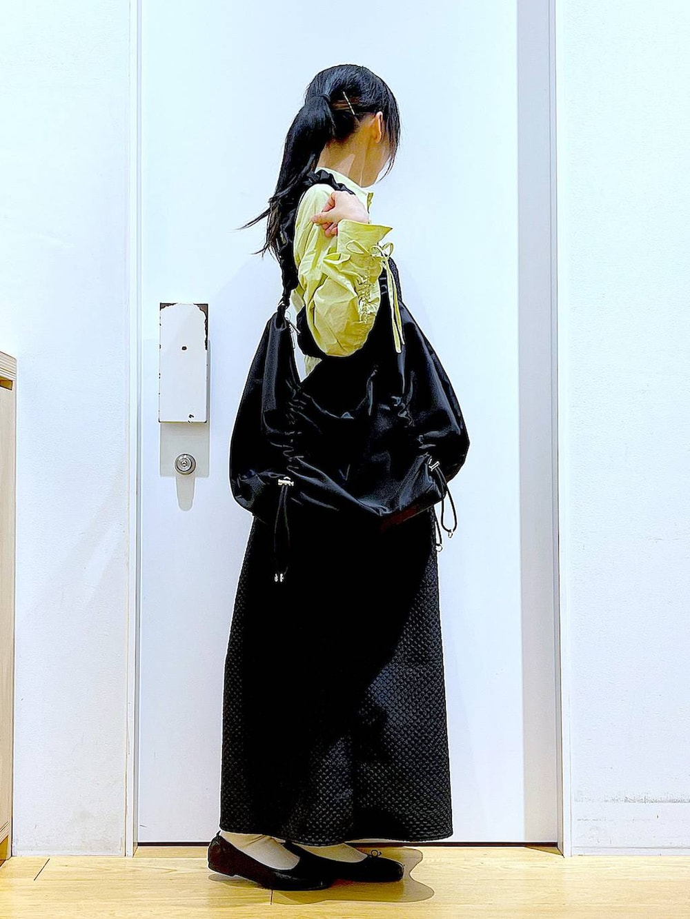 グリーン系のシャツ/ブラウス、ブラック系のバレエシューズ、ブラック系のショルダーバッグを着用したレディースの春コーディネートの4枚目の写真