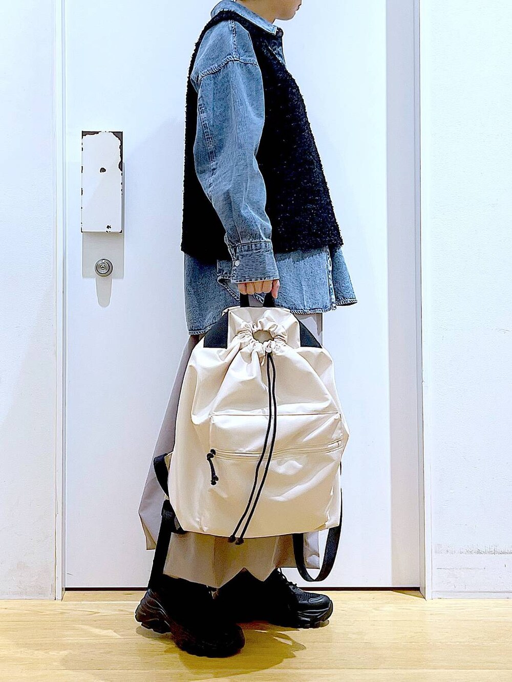 ブルー系のシャツ/ブラウス、ブラック系のスニーカー、ホワイト系のバックパック/リュックを着用したレディースの春コーディネートの4枚目の写真