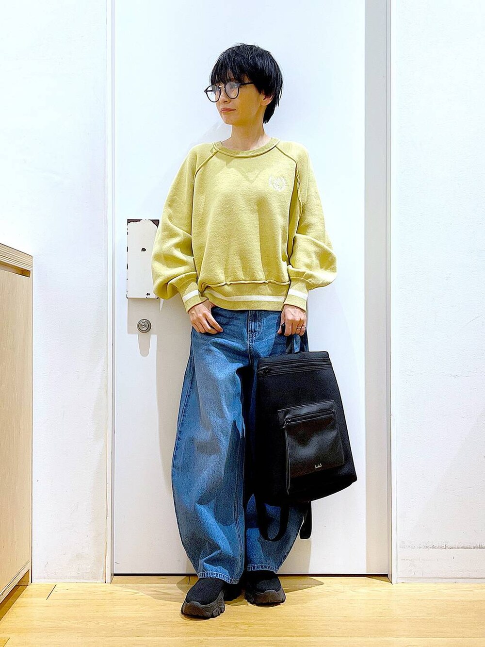 ブルー系のデニムパンツ、ブラック系のバックパック/リュック、ブラック系のブーツを着用したレディースの冬コーディネートの2枚目の写真