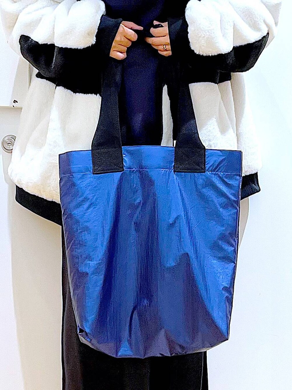 グレー系のスカート、ホワイト系のブルゾン、ブラック系のブーツを着用したレディースの冬コーディネートの9枚目の写真