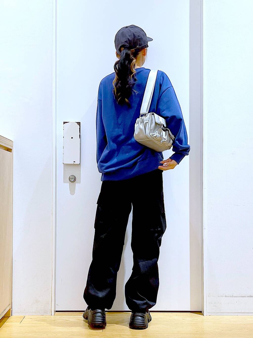 ブラック系のカーゴパンツ、ブラック系のスニーカー、ブルー系のスウェットを着用したレディースの冬コーディネートの5枚目の写真