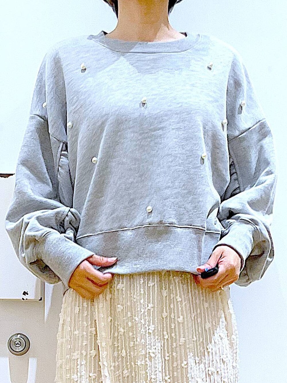 ホワイト系のハンドバッグ、グレー系のスウェット、ベージュ系のブーツを着用したレディースの秋コーディネートの7枚目の写真