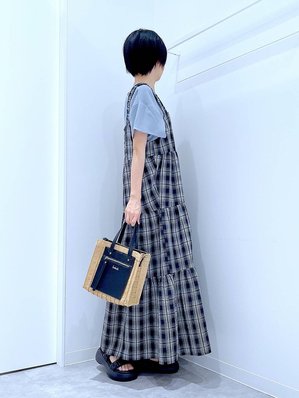 ベージュ系のショルダーバッグ、ブラック系のサンダル、ブラック系のワンピースを着用したレディースの夏コーディネートの4枚目の写真