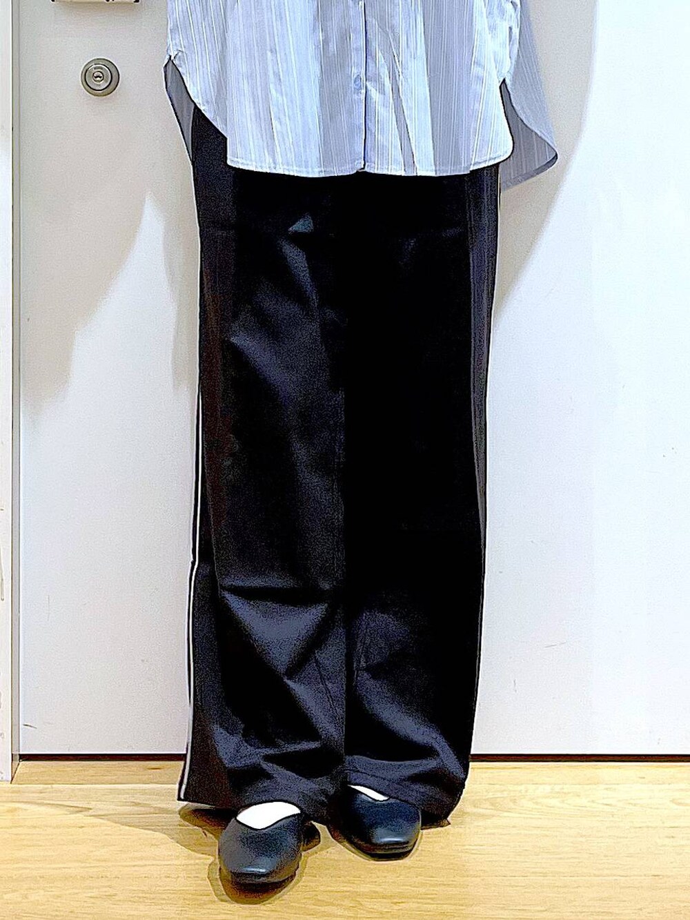 ブラック系のスラックス、ホワイト系のトートバッグ、ブラック系のパンプスを着用したレディースの春コーディネートの7枚目の写真