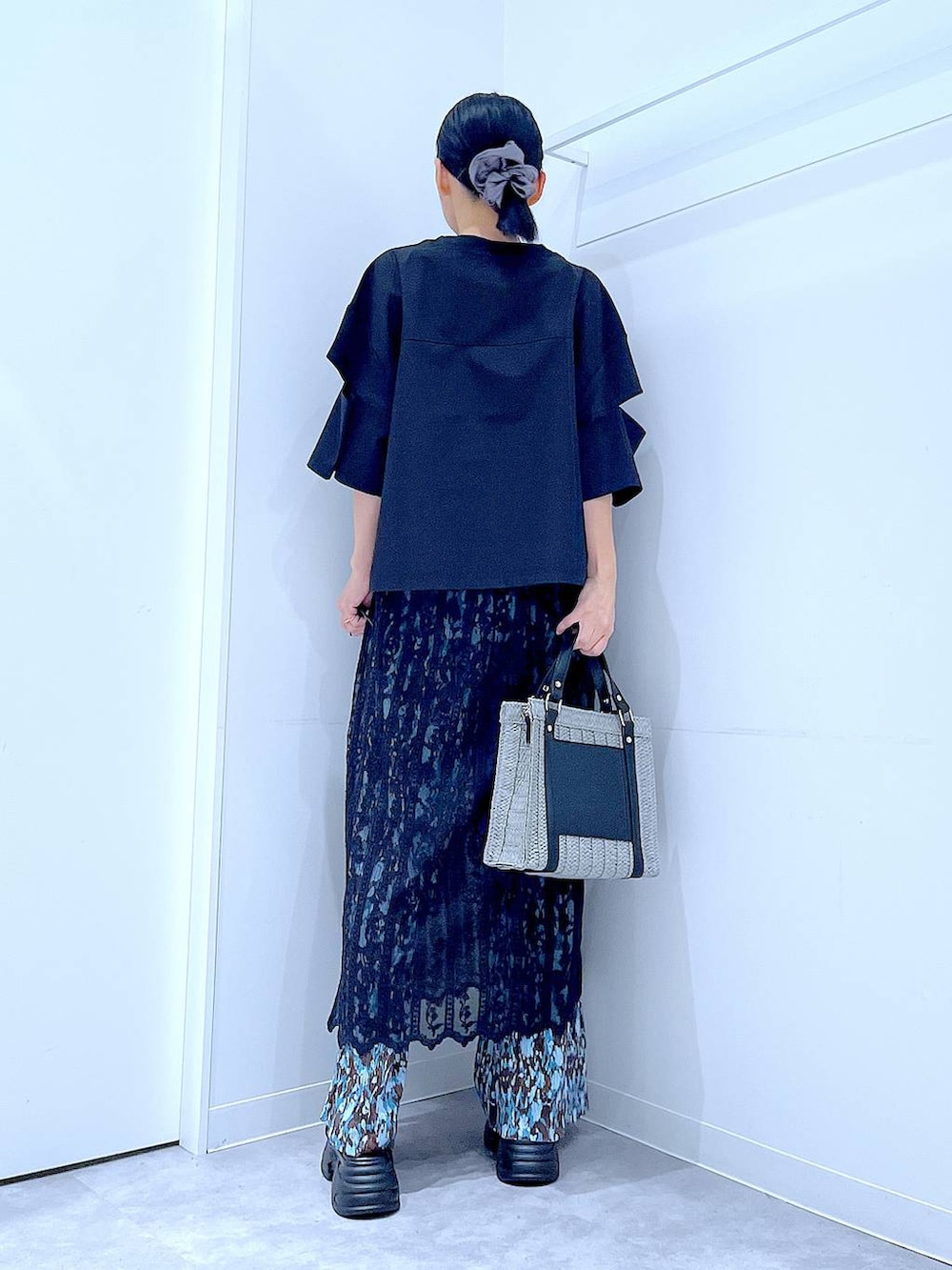 グレー系のショルダーバッグ、ブラック系のサンダル、ブラック系のTシャツ/カットソーを着用したレディースの夏コーディネートの5枚目の写真