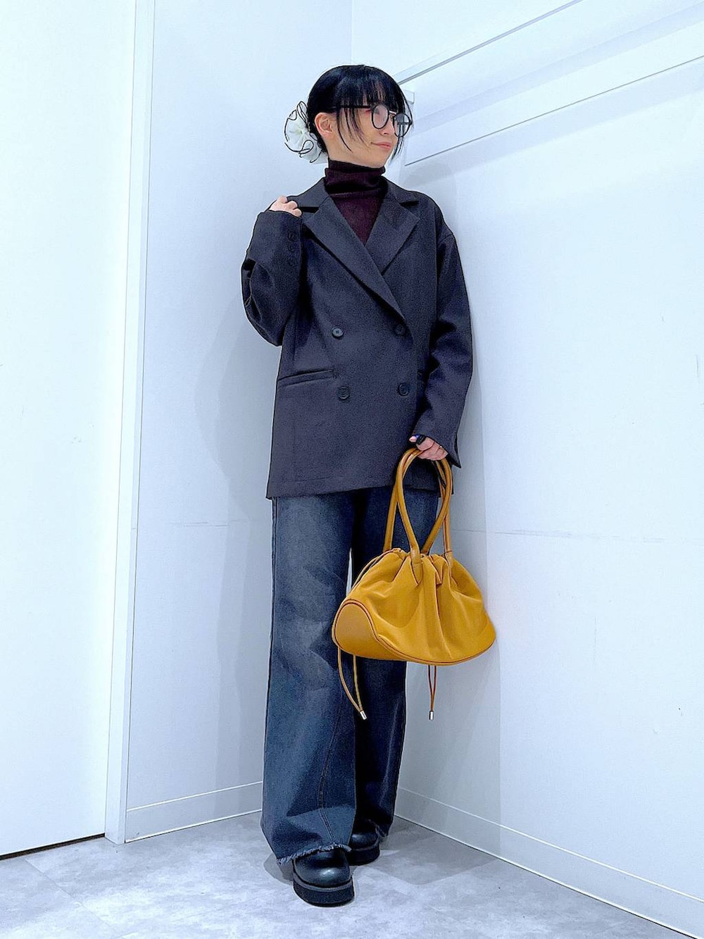 ブラウン系のハンドバッグ、ブラウン系のニット/セーター、グレー系のテーラードジャケットを着用したレディースの冬コーディネートの2枚目の写真