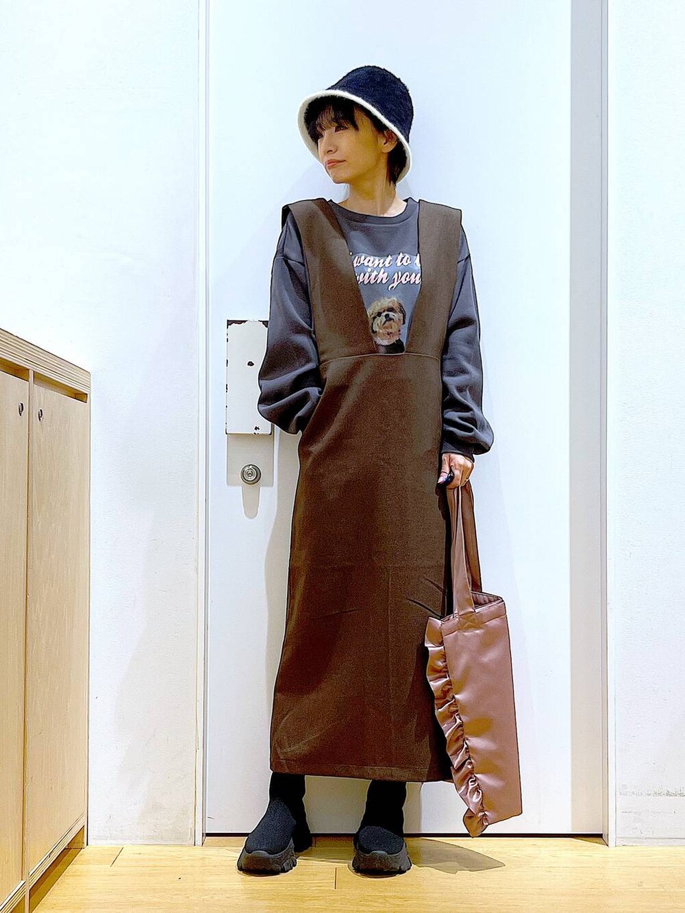 ブラック系のブーツ、ブラウン系のサロペット/オーバーオール、ピンク系のトートバッグを着用したレディースの冬コーディネートの2枚目の写真