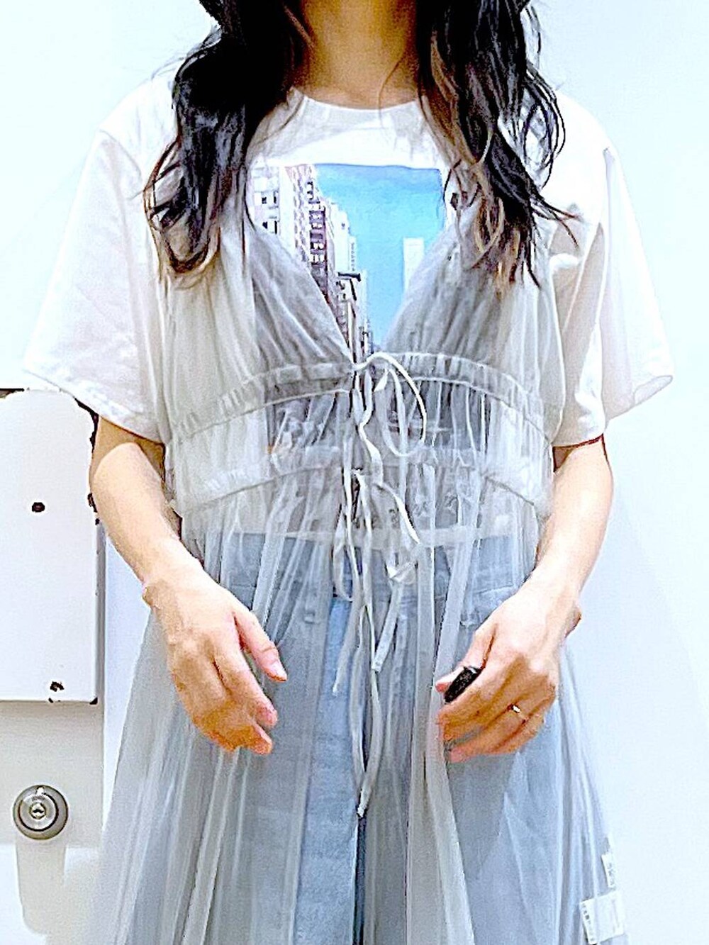 グレー系のワンピース、ブルー系のデニムパンツ、ブラック系のショルダーバッグを着用したレディースの夏コーディネートの7枚目の写真