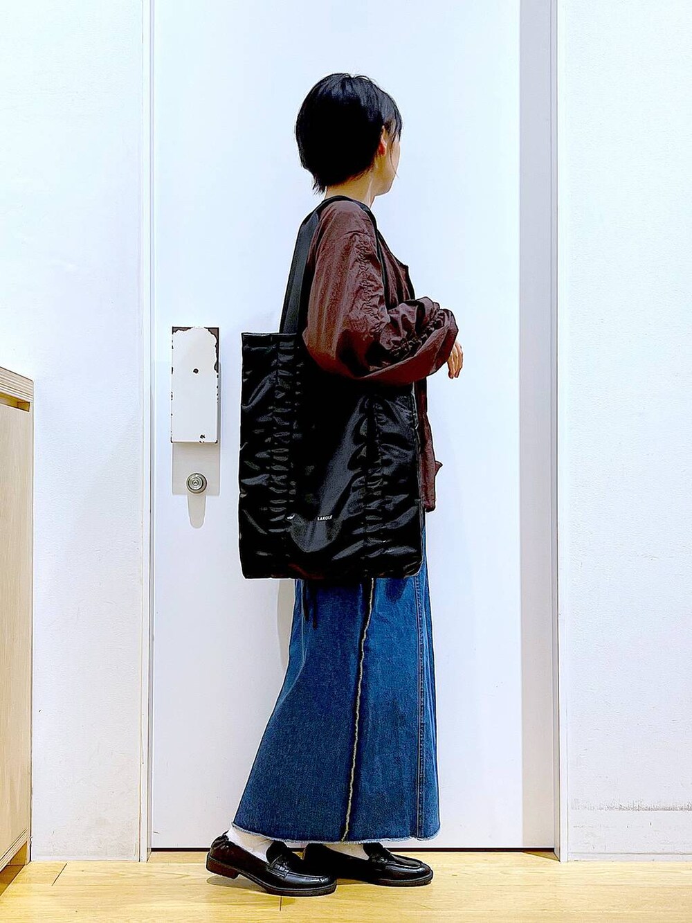 ブラック系のローファー、ブルー系のデニムスカート、ブラック系のTシャツ/カットソーを着用したレディースの秋コーディネートの4枚目の写真