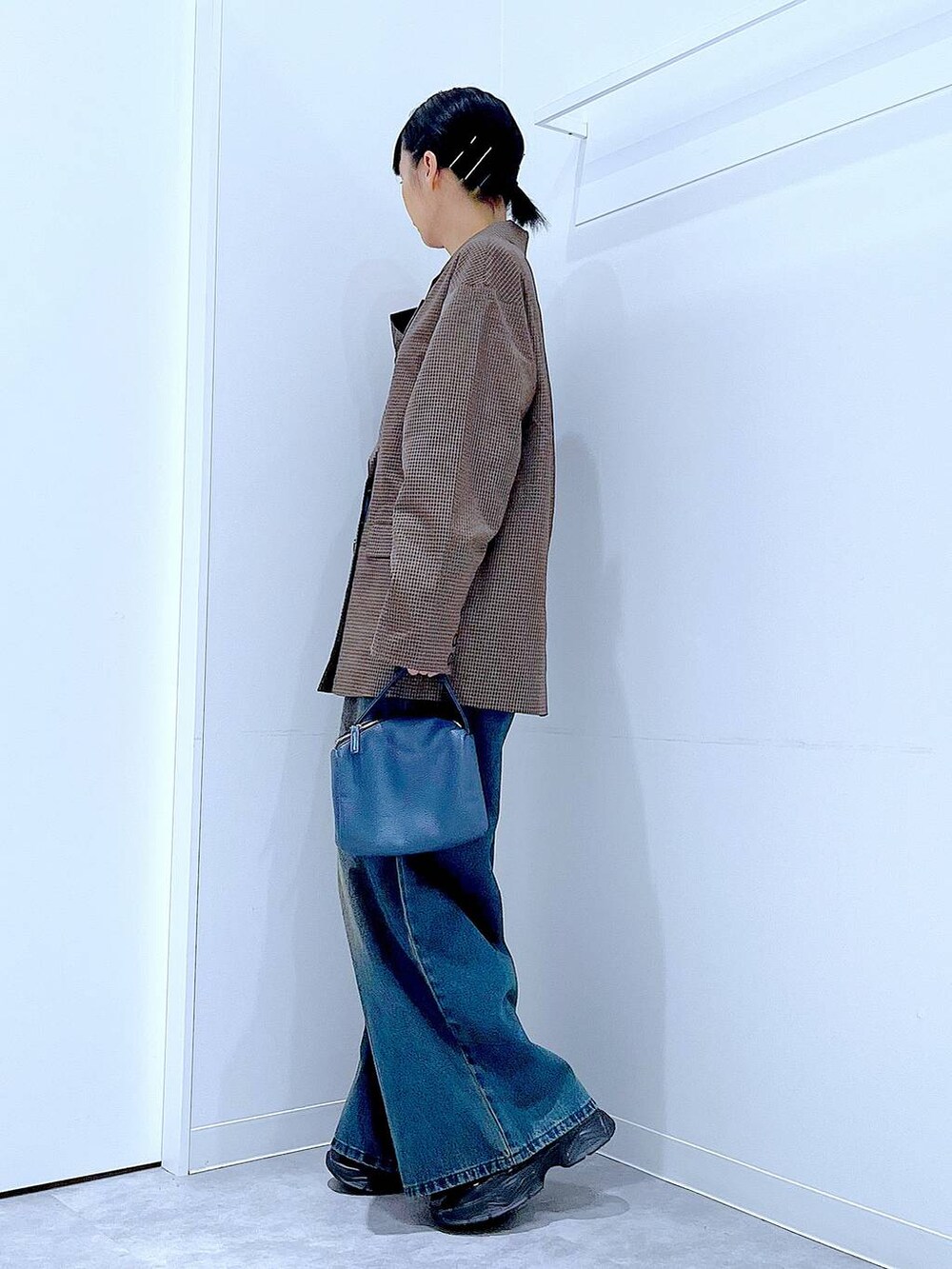 ブラック系のローファー、ブルー系のショルダーバッグ、ブルー系のデニムパンツを着用したレディースの秋コーディネートの3枚目の写真