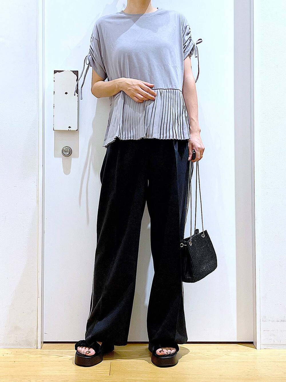 ブラック系のサンダル、ブラック系のスラックス、グレー系のTシャツ/カットソーを着用したレディースの秋コーディネートの6枚目の写真