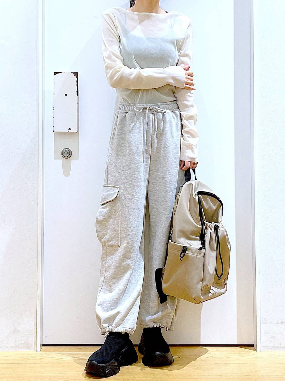 グレー系のスウェットパンツ、ベージュ系のバックパック/リュック、ブラック系のスニーカーを着用したレディースの春コーディネートの6枚目の写真