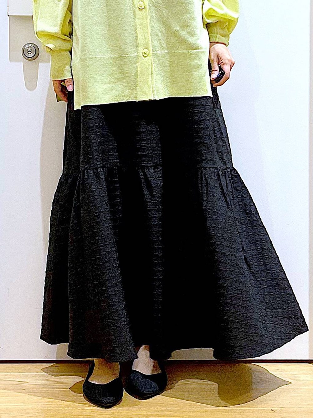 ブラック系のワンピース、グリーン系のカーディガン/ボレロ、ブラック系のショルダーバッグを着用したレディースの春コーディネートの8枚目の写真