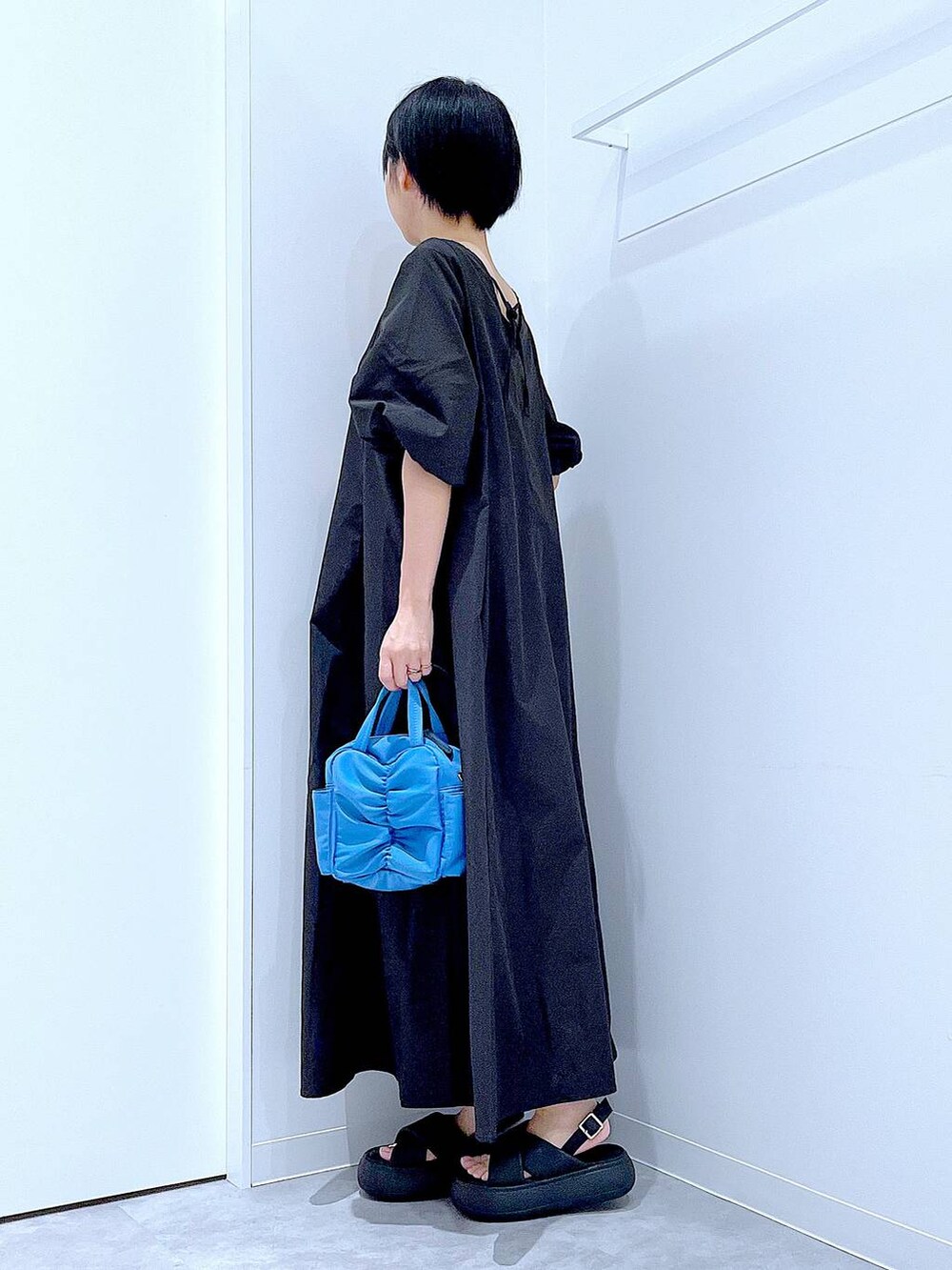 ブラック系のサンダル、ブラック系のワンピースを着用したレディースの夏コーディネートの3枚目の写真