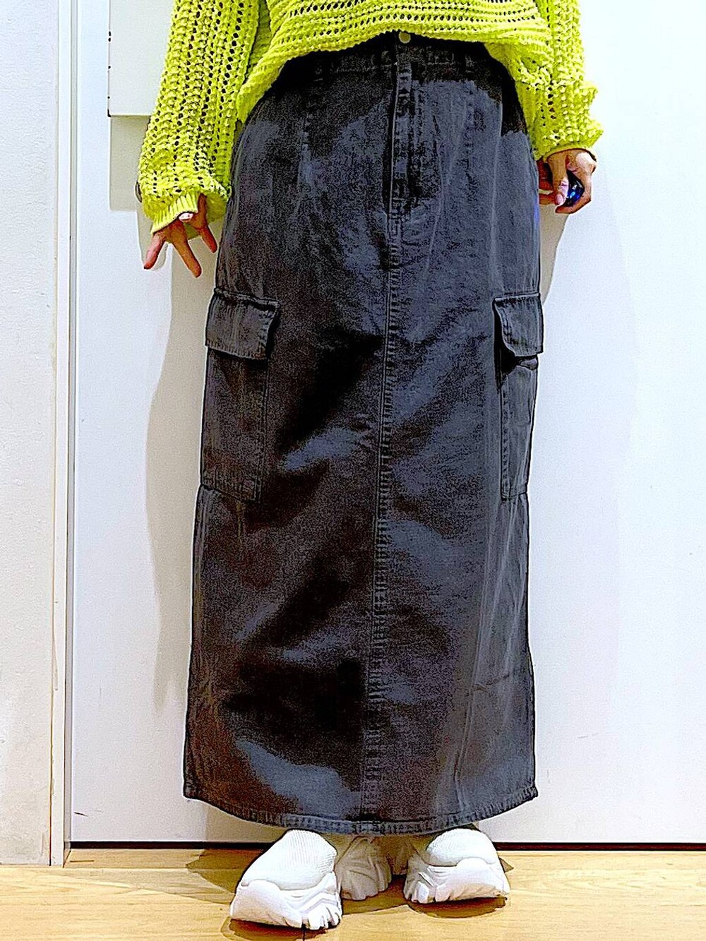 グレー系のデニムスカート、ベージュ系のスニーカー、ブラック系のショルダーバッグを着用したレディースの春コーディネートの8枚目の写真