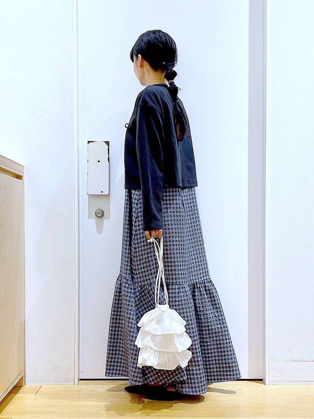 ホワイト系のショルダーバッグ、ブラック系のパンプス、ブルー系のワンピースを着用したレディースの春コーディネートの3枚目の写真