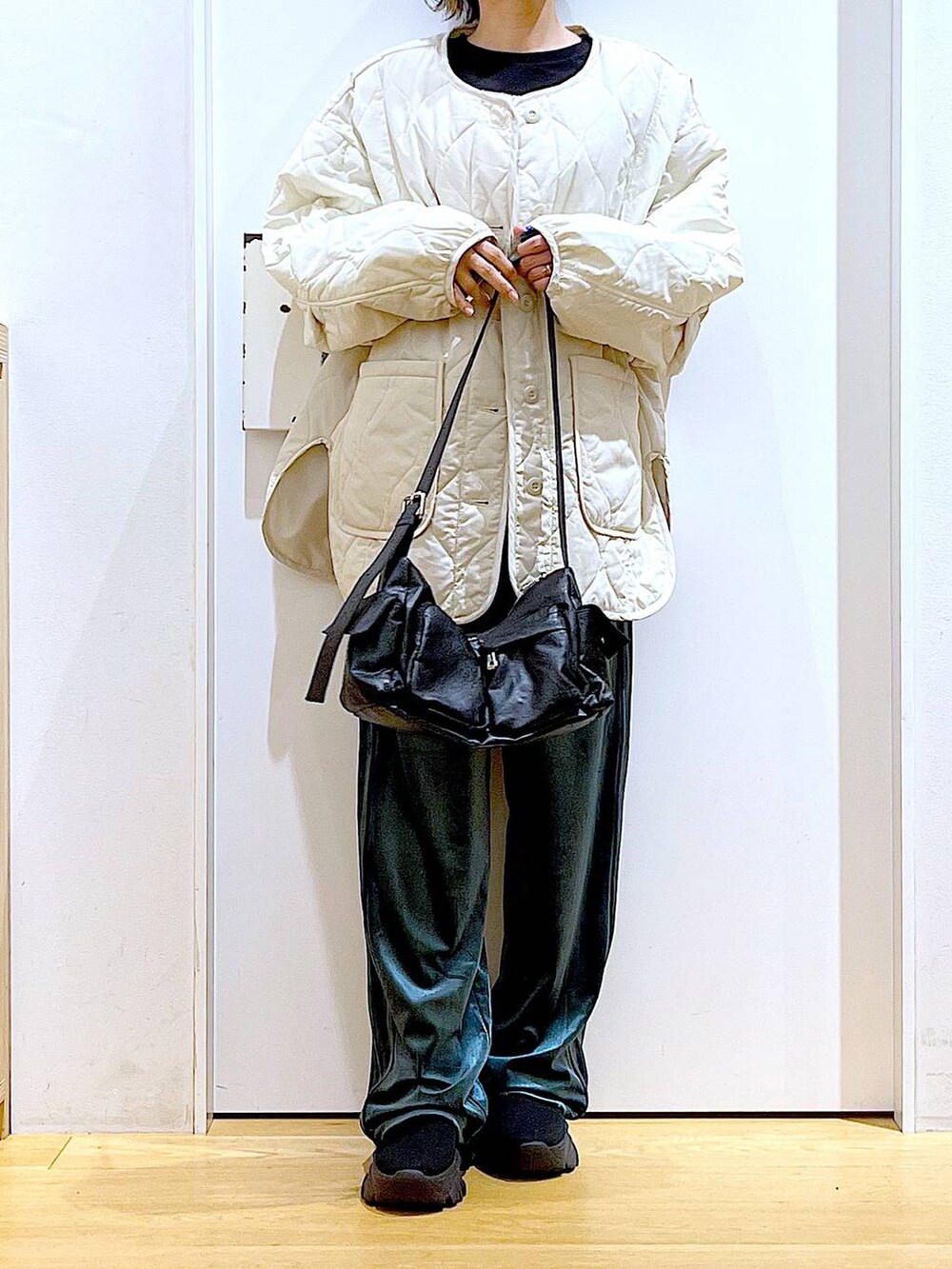 ベージュ系のブルゾン、ブラック系のTシャツ/カットソー、ブラック系のブーツを着用したレディースの冬コーディネートの6枚目の写真