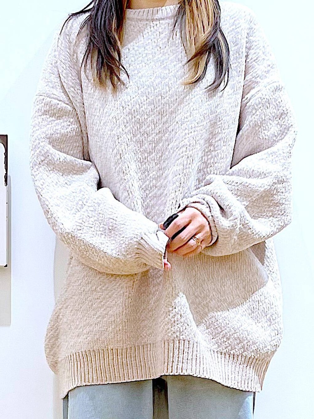 ホワイト系のニット/セーター、ブラック系のショルダーバッグ、ブラック系のブーツを着用したレディースの冬コーディネートの7枚目の写真