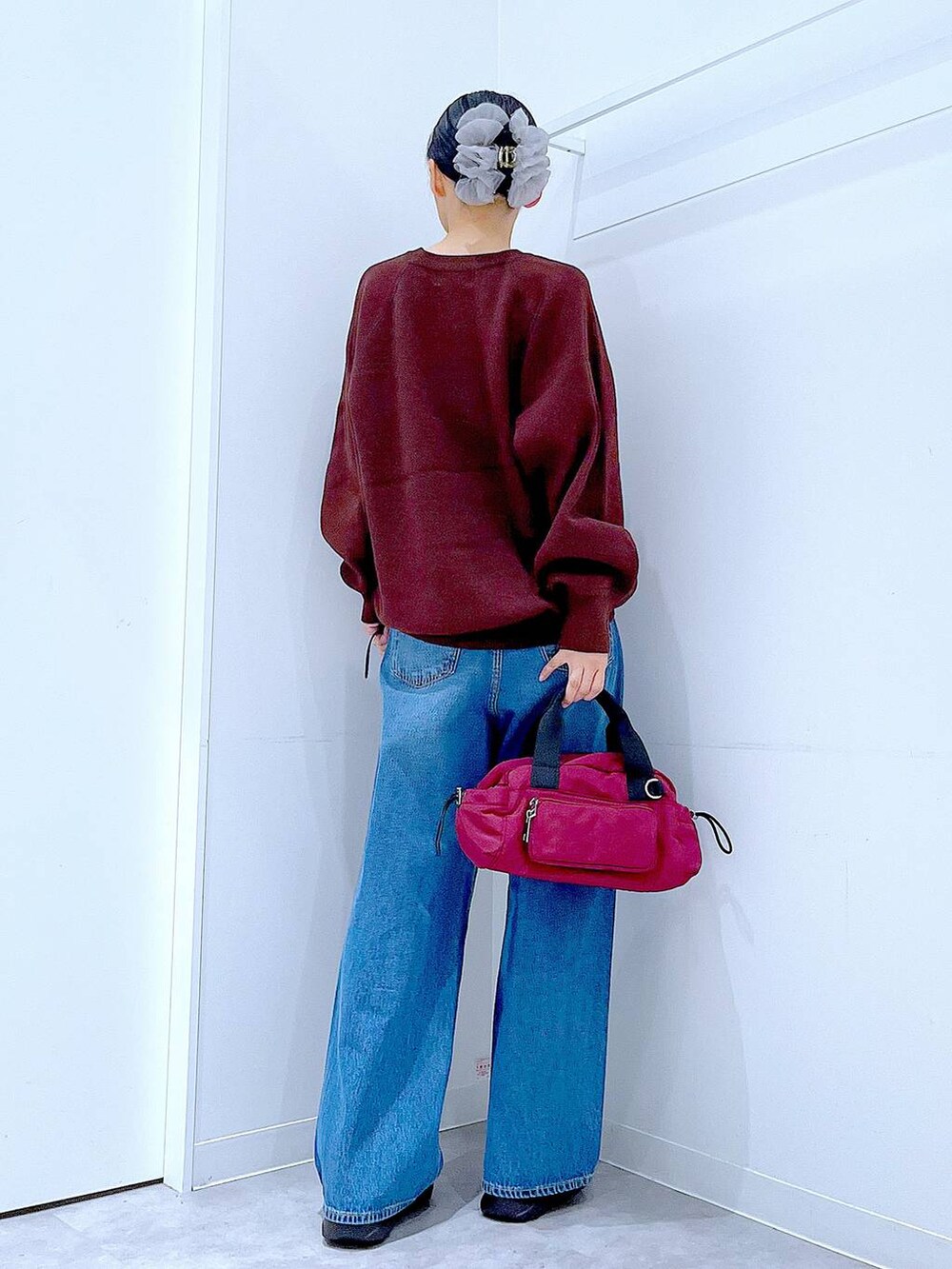 ブルー系のデニムパンツ、ブラウン系のニット/セーター、ブラック系のローファーを着用したレディースの秋コーディネートの5枚目の写真