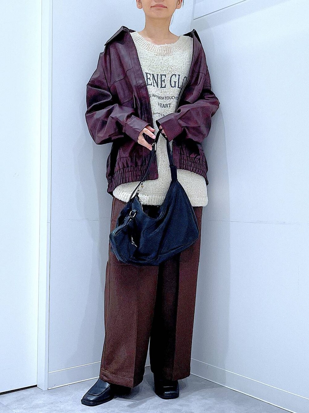 レッド系のブルゾン、ホワイト系のニット/セーター、ブラック系のブーツを着用したレディースの秋コーディネートの6枚目の写真