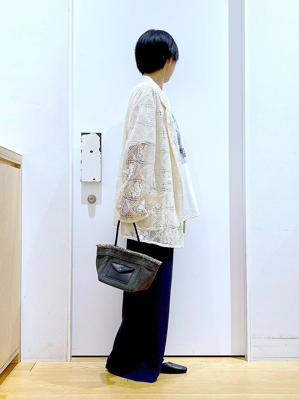 ブラック系のパンプス、ブラック系のショルダーバッグ、ホワイト系のテーラードジャケットを着用したレディースの春コーディネートの4枚目の写真