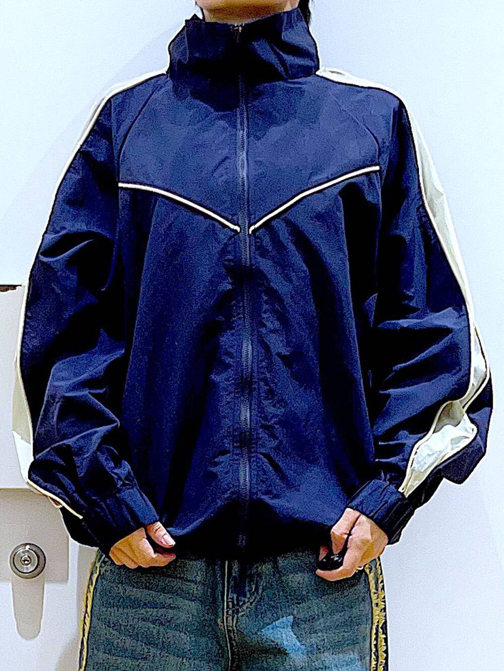 ブラック系のスニーカー、ブルー系のデニムパンツ、ブルー系のブルゾンを着用したレディースの春コーディネートの7枚目の写真