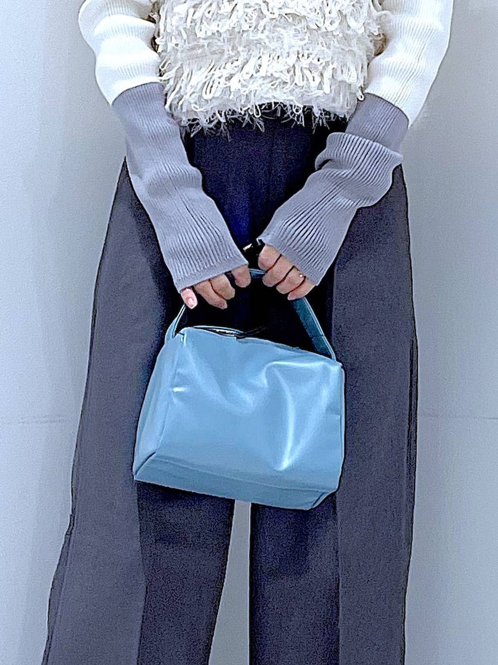 ブラック系のブーツ、グレー系のスラックス、ホワイト系のベストを着用したレディースの冬コーディネートの9枚目の写真