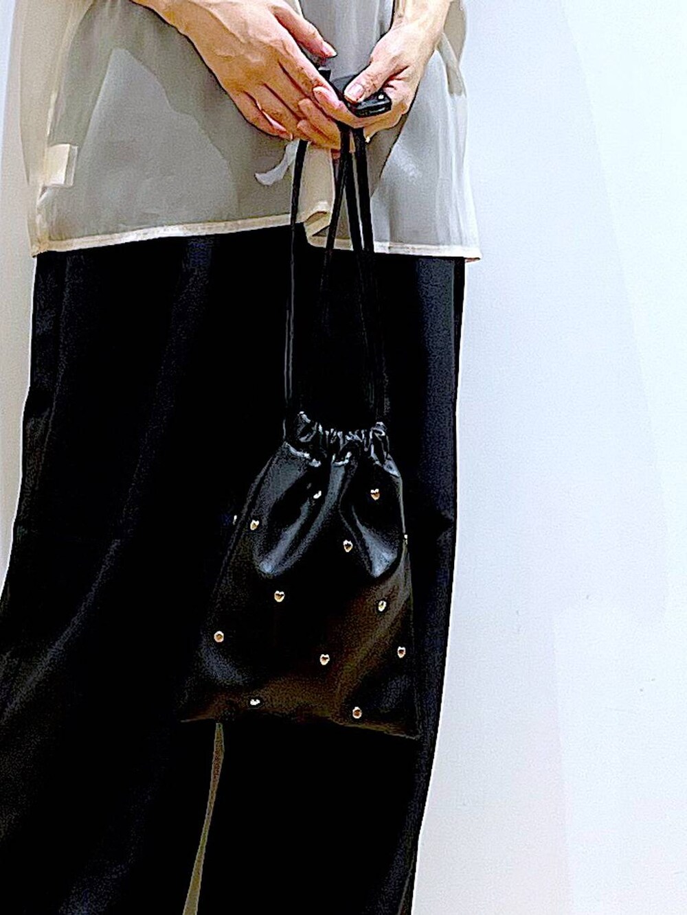 ブラック系のサンダル、ブラック系のニット/セーター、ブラック系のショルダーバッグを着用したレディースの夏コーディネートの9枚目の写真