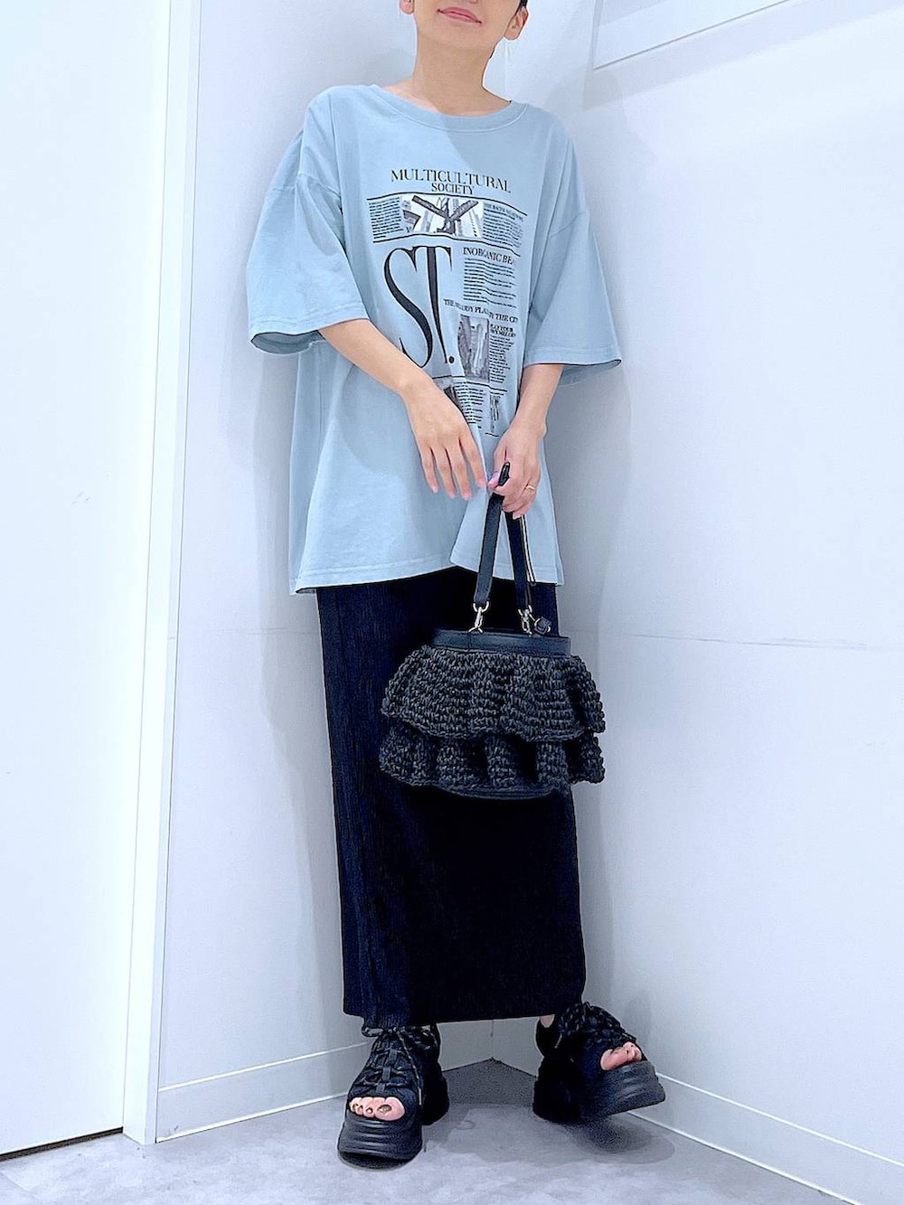 ブラック系のショルダーバッグ、ブラック系のサンダル、ブルー系のTシャツ/カットソーを着用したレディースの夏コーディネートの6枚目の写真
