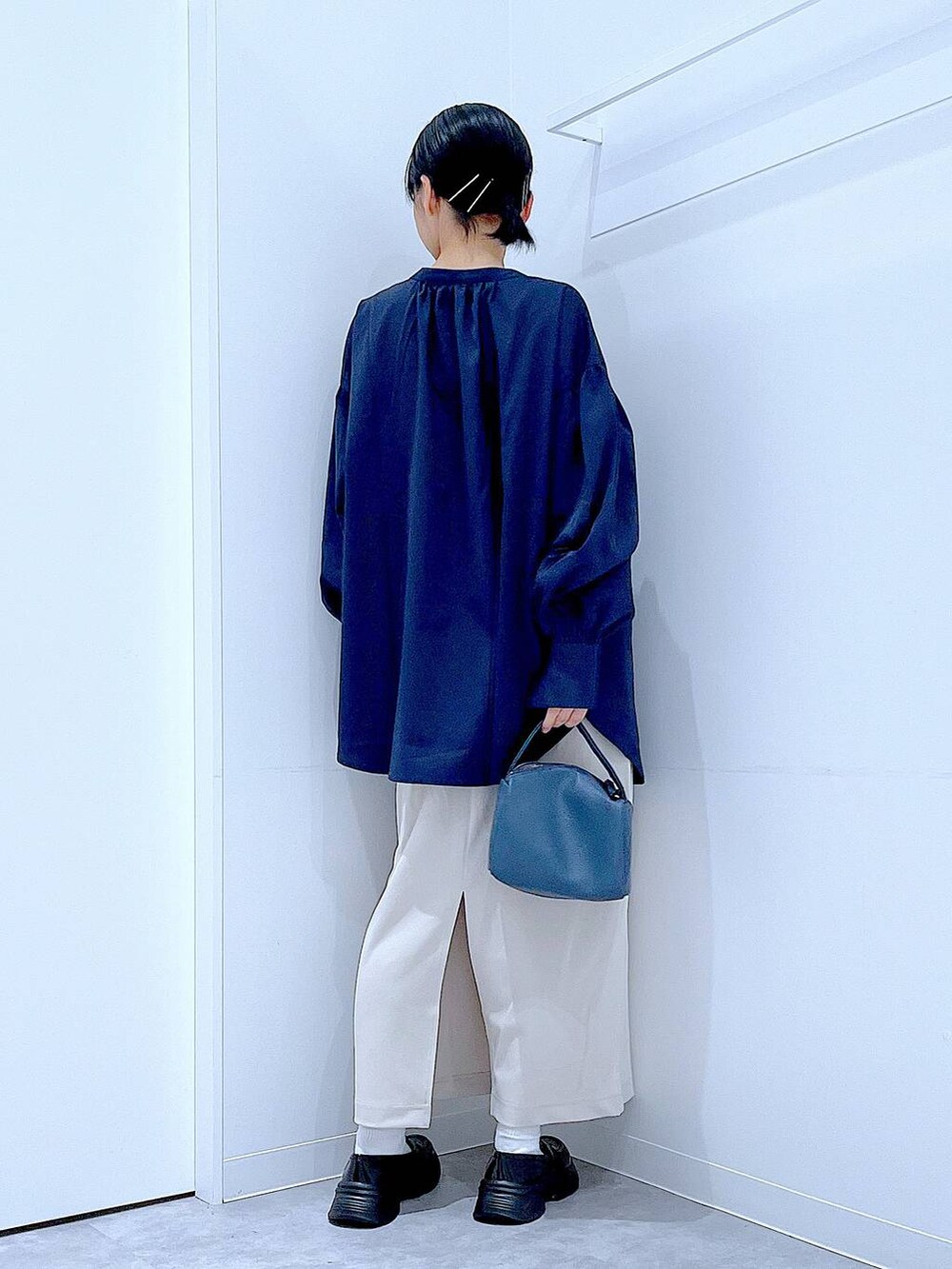 ベージュ系のスカート、ブラック系のローファー、ブルー系のショルダーバッグを着用したレディースの秋コーディネートの5枚目の写真