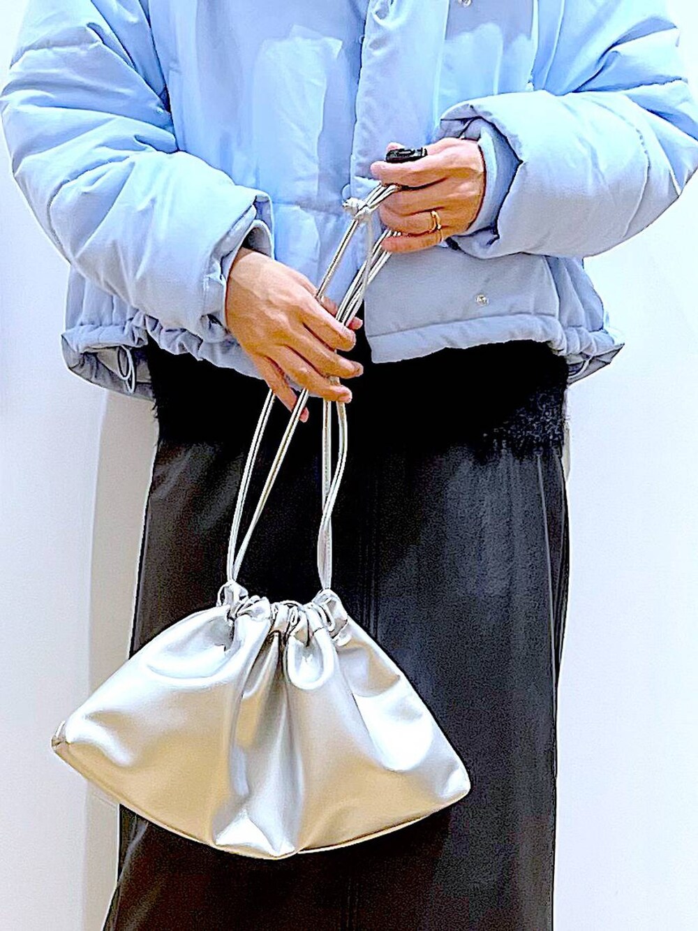 ブラック系のブーツ、シルバー系のショルダーバッグ、ブルー系のナイロンジャケットを着用したレディースの冬コーディネートの9枚目の写真