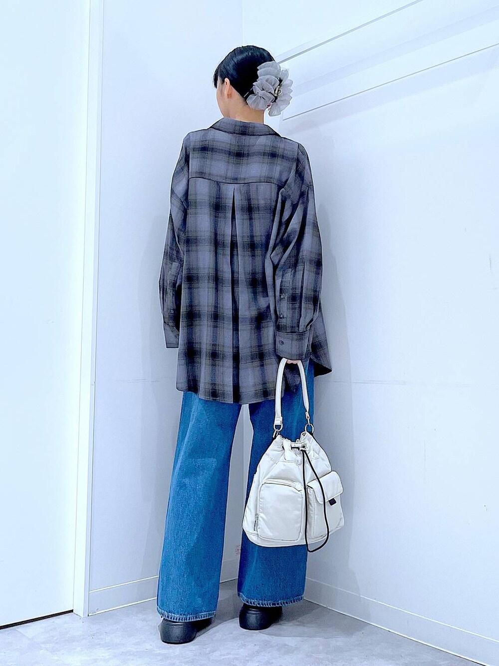 ブルー系のデニムパンツ、グレー系のシャツ/ブラウス、ホワイト系のハンドバッグを着用したレディースの秋コーディネートの5枚目の写真