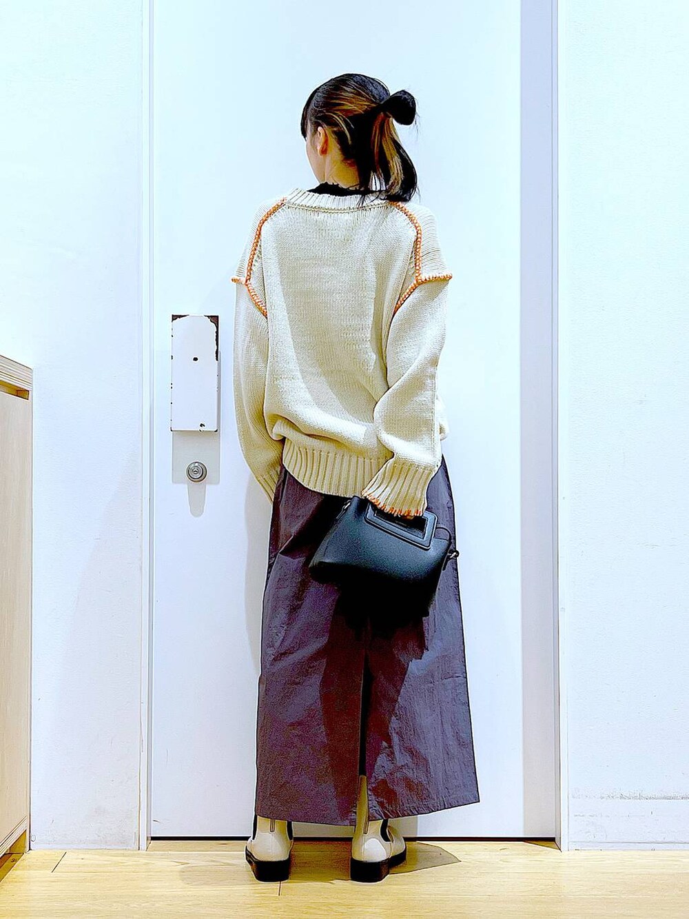 ブラック系のTシャツ/カットソー、ベージュ系のブーツ、ブラック系のショルダーバッグを着用したレディースの冬コーディネートの5枚目の写真