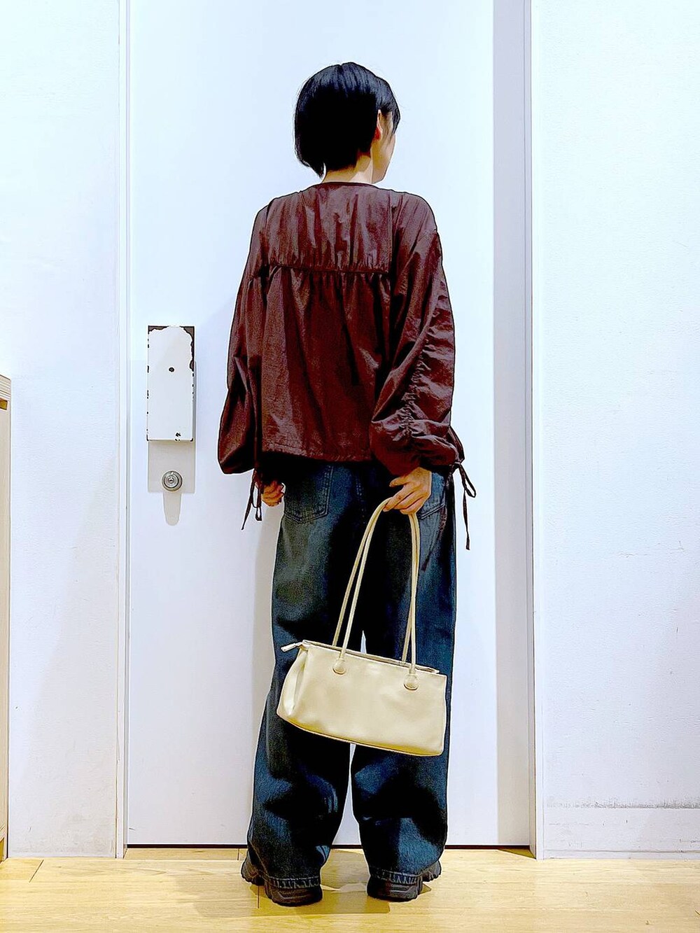 ブラック系のブーツ、ベージュ系のトートバッグ、ブラウン系のブルゾンを着用したレディースの冬コーディネートの5枚目の写真