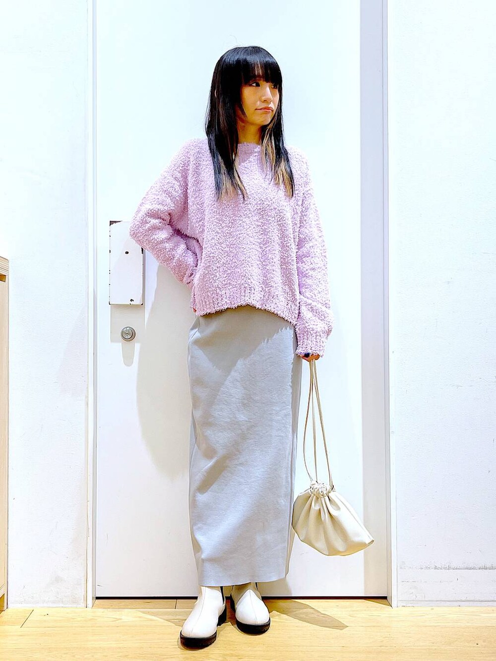 パープル系のニット/セーター、ベージュ系のブーツ、ベージュ系のショルダーバッグを着用したレディースの冬コーディネートの2枚目の写真