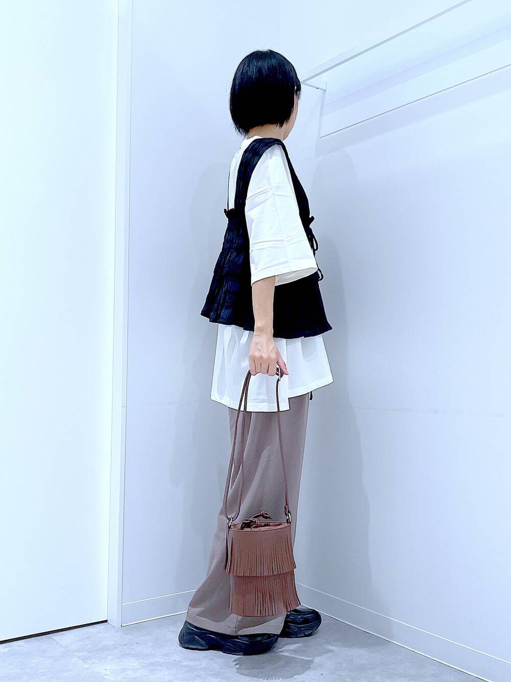 ブラック系のローファー、ブラウン系のショルダーバッグ、ブラウン系のその他パンツを着用したレディースの秋コーディネートの4枚目の写真