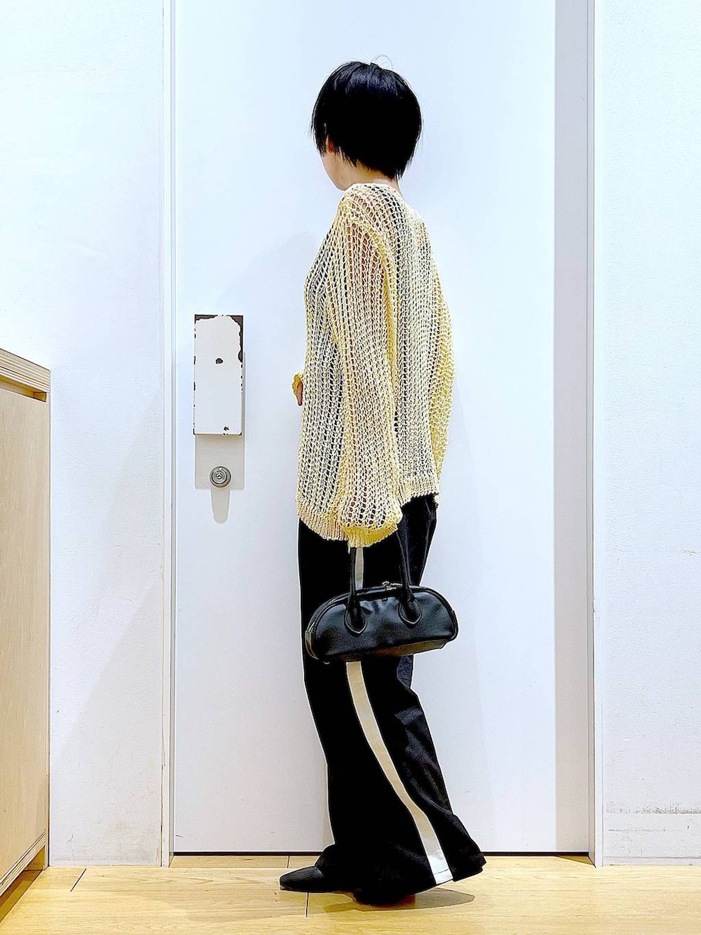 ブラック系のスラックス、ブラック系のボストンバッグ、ブラック系のパンプスを着用したレディースの夏コーディネートの3枚目の写真