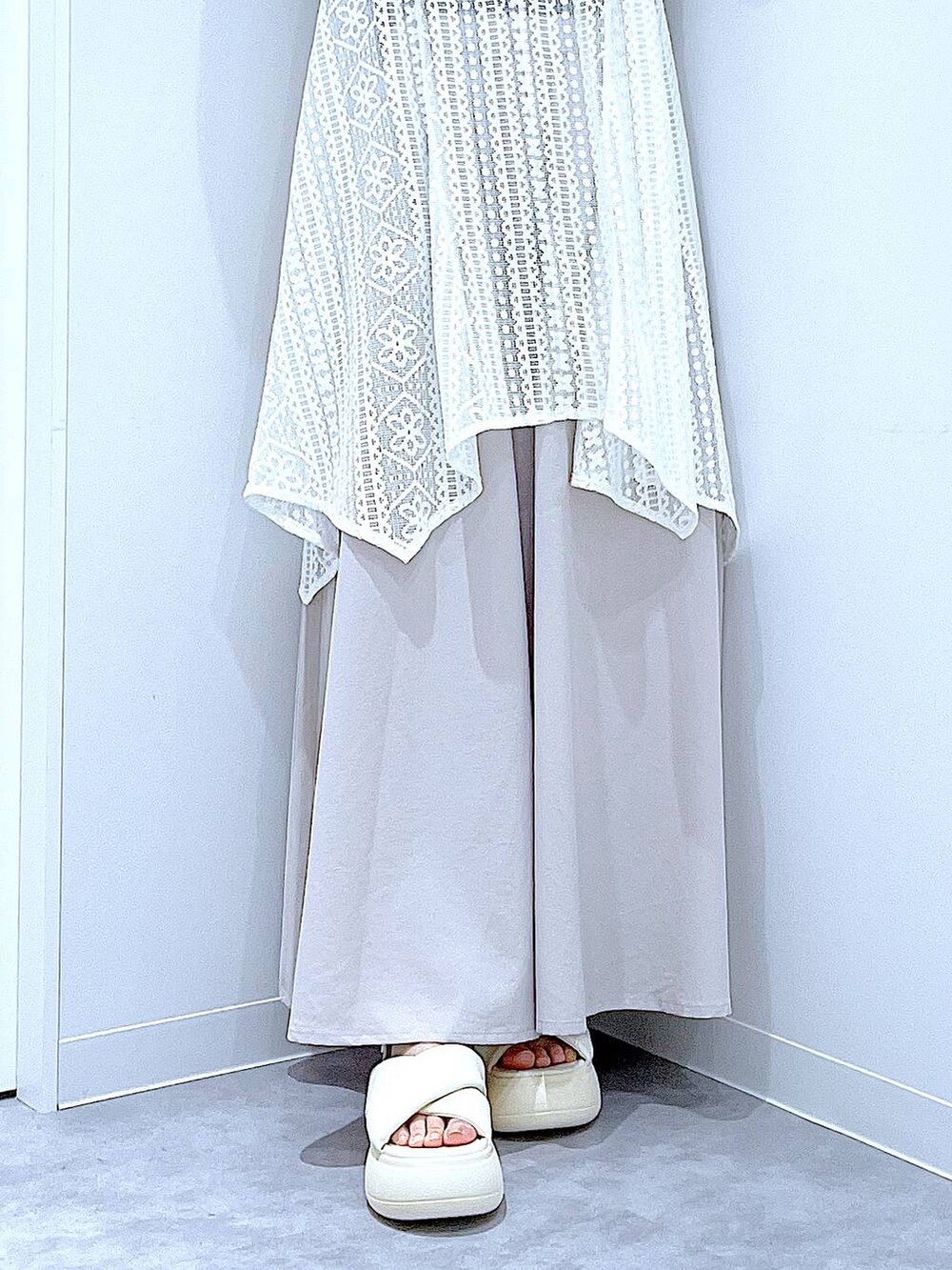 ホワイト系のショルダーバッグ、ホワイト系のサンダル、ブラック系のTシャツ/カットソーを着用したレディースの夏コーディネートの8枚目の写真