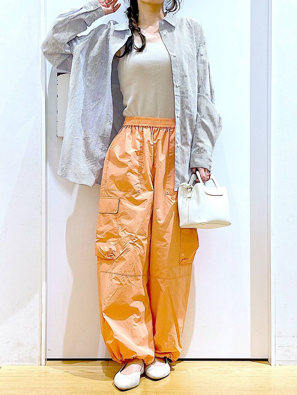 ホワイト系のシャツ/ブラウス、イエロー系のニット/セーター、ホワイト系のショルダーバッグを着用したレディースの春コーディネートの6枚目の写真