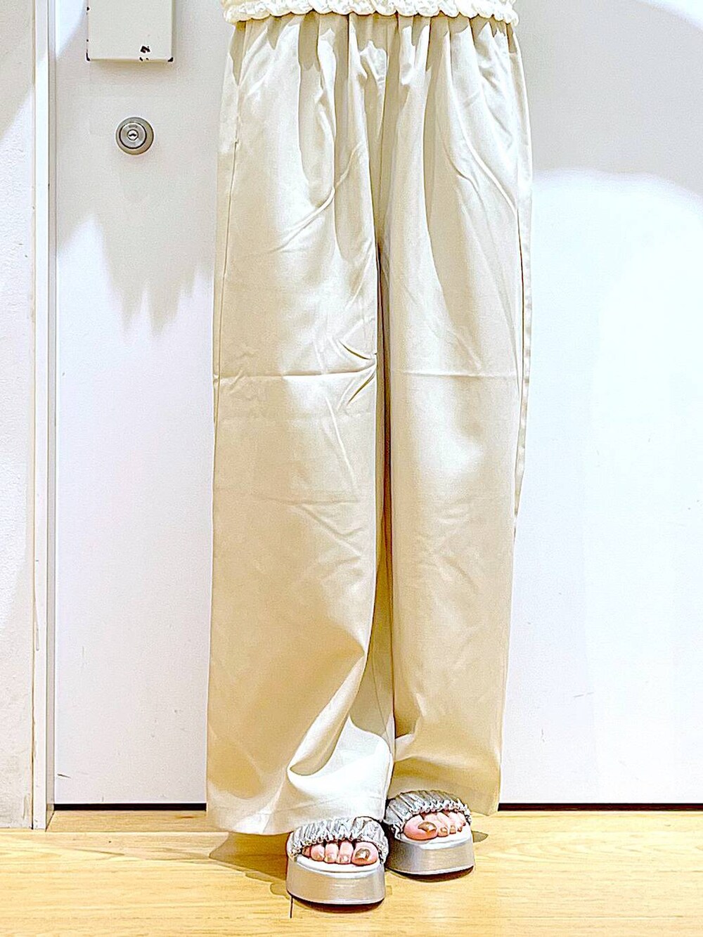 シルバー系のサンダル、ベージュ系のショルダーバッグ、ベージュ系のTシャツ/カットソーを着用したレディースの夏コーディネートの8枚目の写真