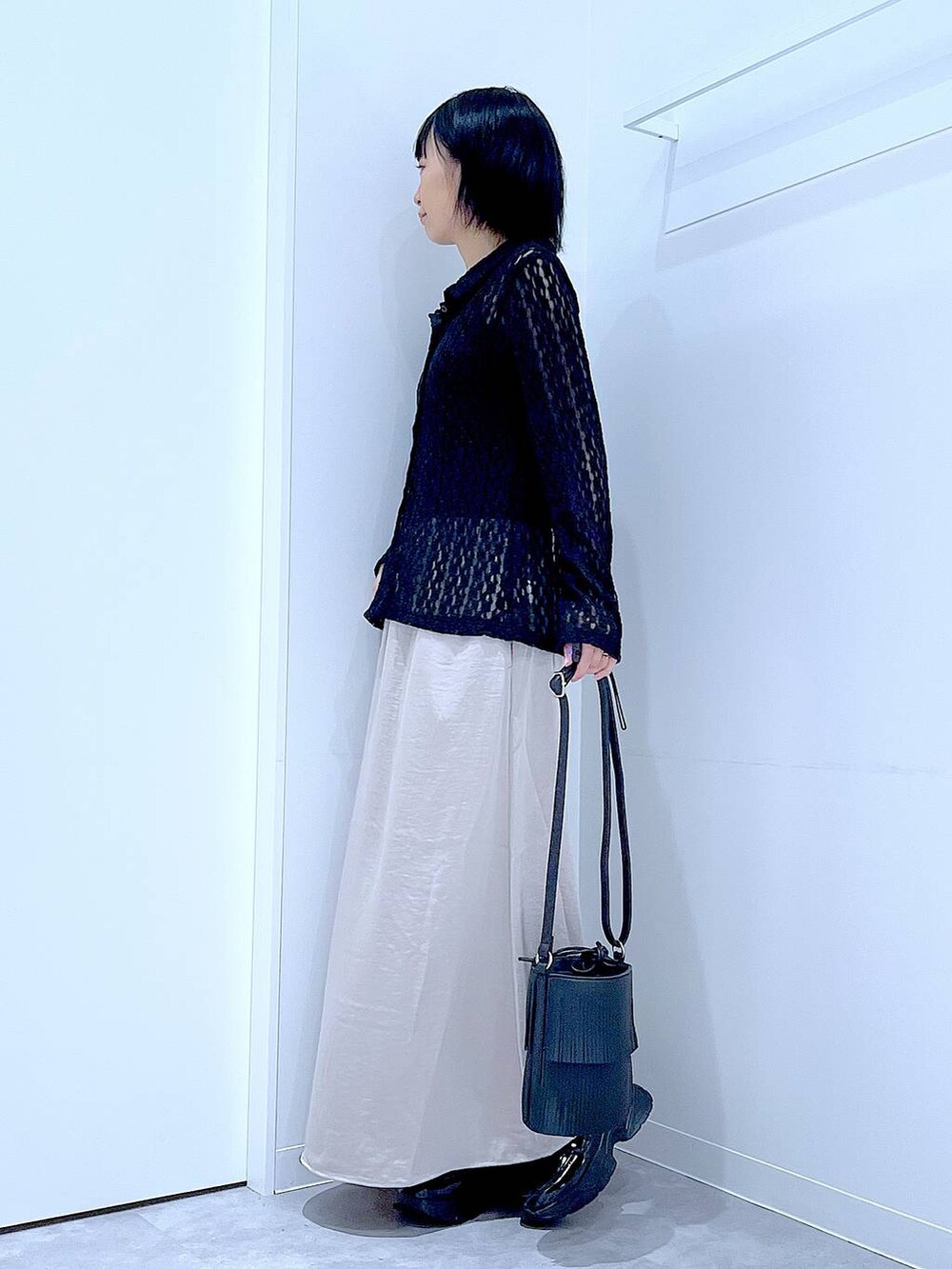 ブラック系のローファー、ブラック系のショルダーバッグ、ベージュ系のスカートを着用したレディースの秋コーディネートの3枚目の写真