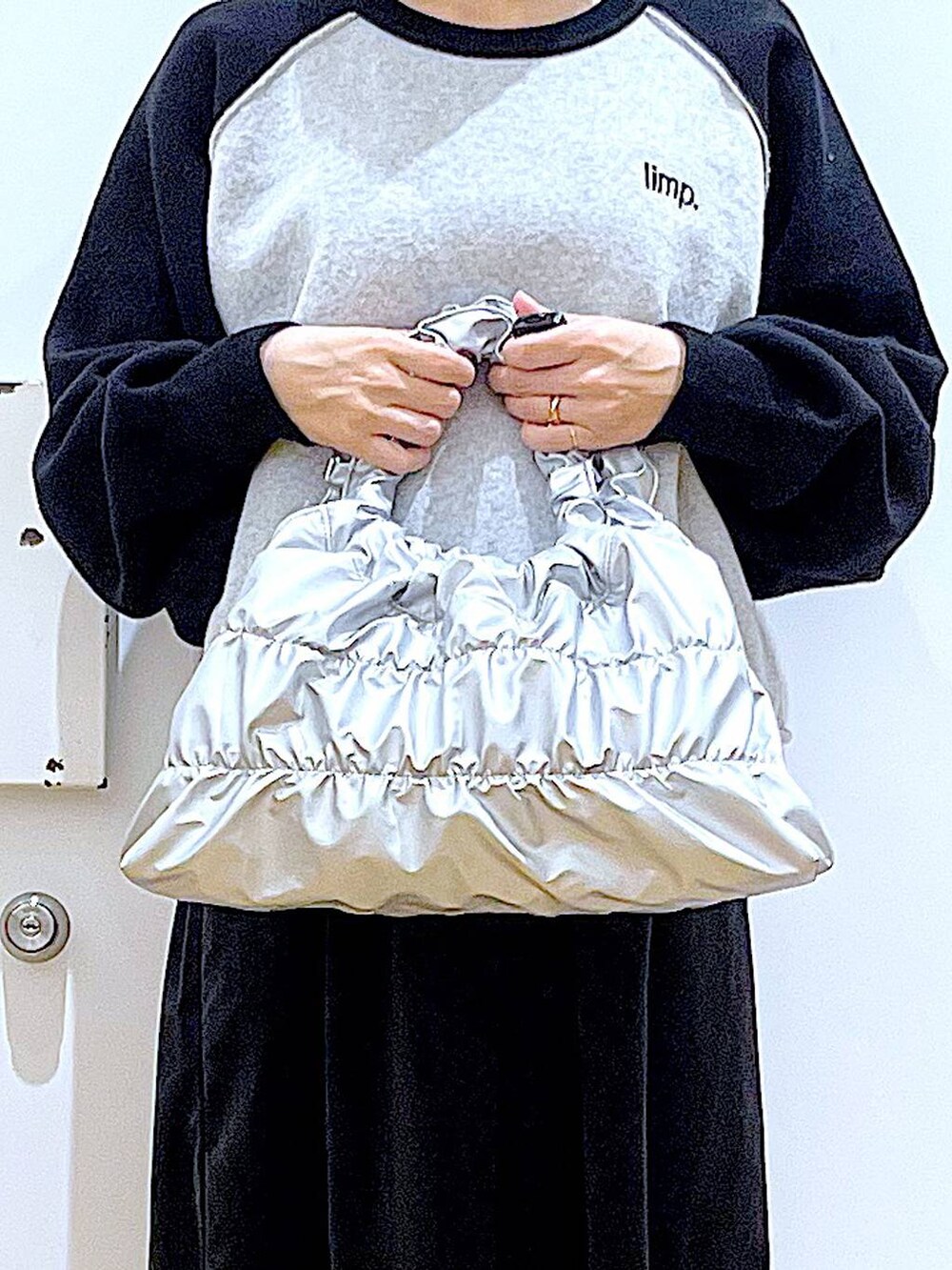 ブラック系のブーツ、シルバー系のショルダーバッグ、ブラック系のニット/セーターを着用したレディースの冬コーディネートの9枚目の写真