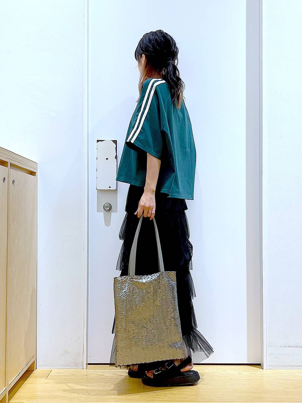 ブラック系のサンダル、シルバー系のトートバッグ、ブラック系のスカートを着用したレディースの夏コーディネートの3枚目の写真