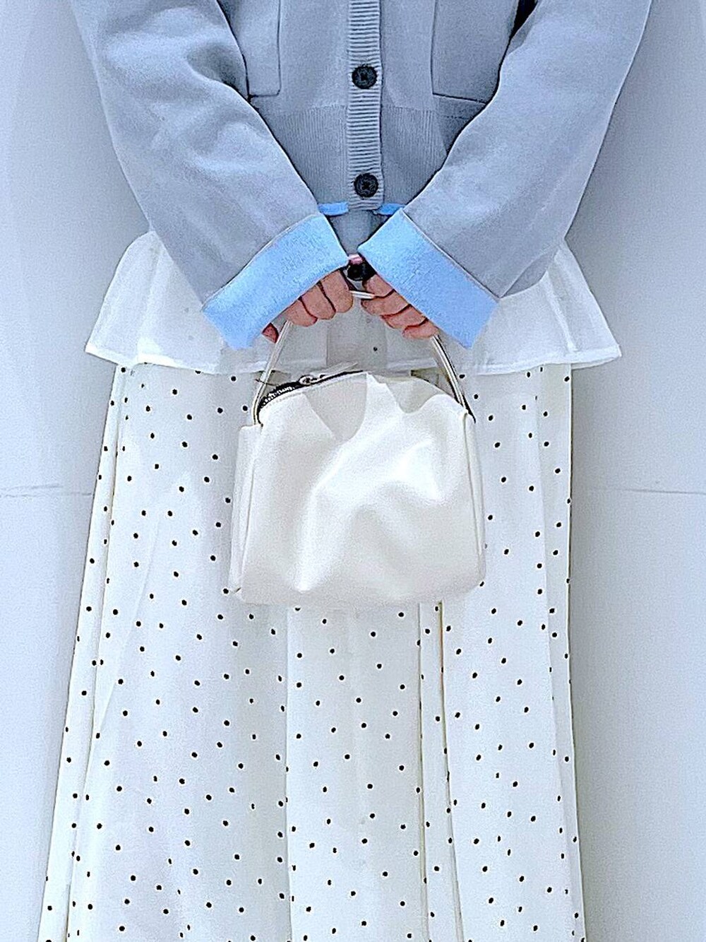 ホワイト系のショルダーバッグ、グレー系のカーディガン/ボレロ、ホワイト系のスカートを着用したレディースの春コーディネートの9枚目の写真